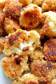 some fried food on a white plate with seasoning sprinkled around the edges