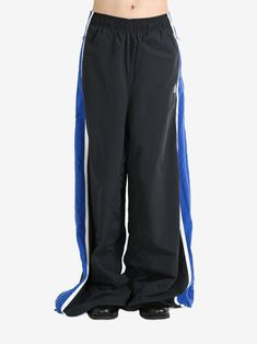 black/blue elasticated waistband two side zip-fastening pockets side stripe detailing wide leg When buying this unisex item, keep in mind that it is graded in standard men's sizing.