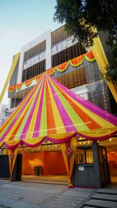 a large colorful tent sitting in front of a tall building