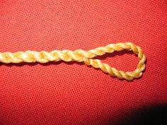 a piece of rope sitting on top of a red cloth