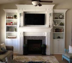 a living room filled with furniture and a flat screen tv mounted on the wall above a fireplace