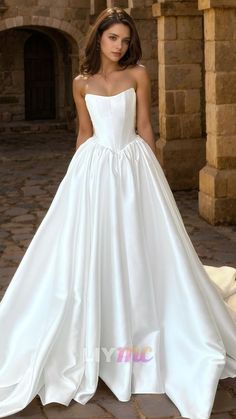 a woman in a white wedding dress standing outside