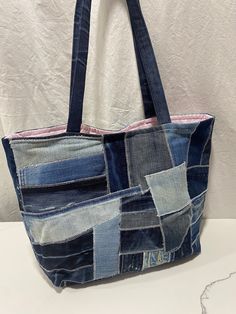 a bag made out of old jeans on a white table with a hole in the side