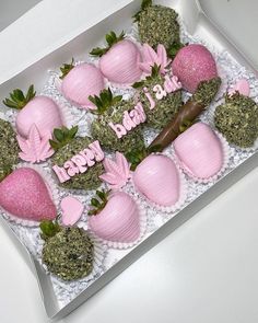 a box filled with lots of pink strawberries on top of a white tablecloth