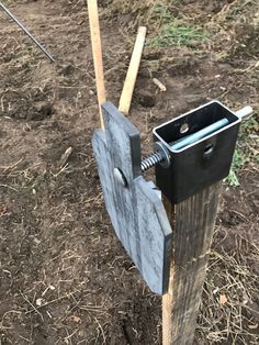 an old tool is stuck in the ground with two wooden poles attached to it's sides