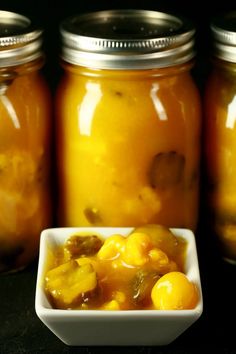 several jars filled with food sitting on top of a black table next to each other