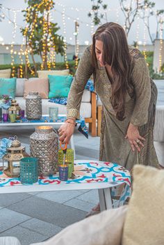 a woman standing over a table filled with lots of gifts on it's side