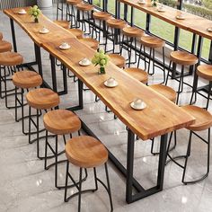 tables and stools are lined up in an empty room with large windows on the side