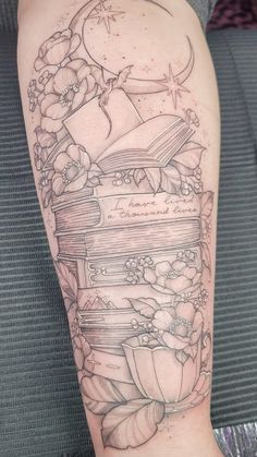 a tattoo with books and flowers on it