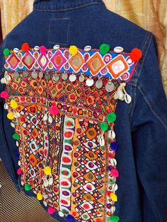 the back of a denim jacket with colorful beaded details