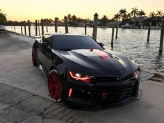 a chevrolet camaro is parked on the side of the water