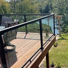 a deck with chairs overlooking the water and trees