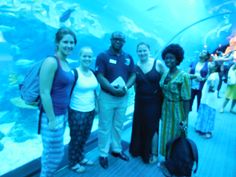 some people are standing in front of an aquarium