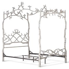 an iron bed frame with white flowers and branches on the headboard is made out of metal