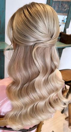 the back of a woman's head with long blonde hair styled into a half - updo