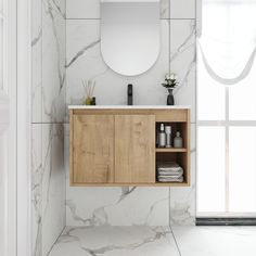 a bathroom with marble walls and flooring has a mirror above the sink that is mounted to the wall