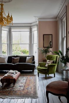 a living room filled with lots of furniture and a chandelier hanging from the ceiling