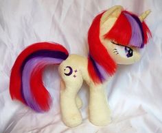 a stuffed pony with red, purple and yellow hair