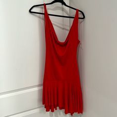 a red dress hanging on a white wall