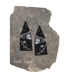 black and white beaded earrings with an image of the moon in space on it