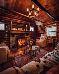 a living room filled with furniture and a fire place in the middle of a wooden wall