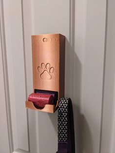 a pair of shoes hanging on a wall next to a cardboard box with a dog's paw painted on it