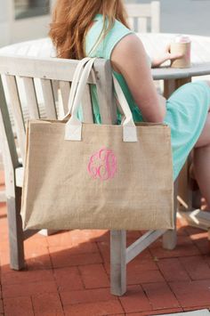 a woman sitting on a bench with a tote bag