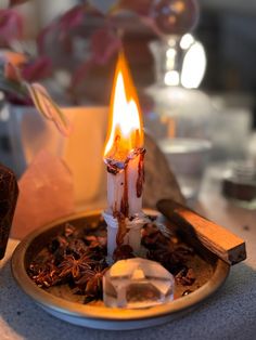 a lit candle sitting on top of a plate