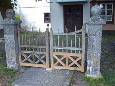 the gate is made out of wood and has two heads on each side, as well as a birdhouse