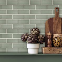 an assortment of fruits and vegetables sitting on a shelf in front of a tiled wall