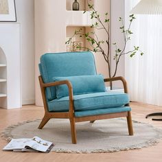 a blue chair sitting on top of a rug in front of a tree and window