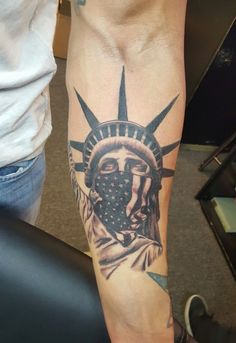 the statue of liberty tattoo is on someone's arm