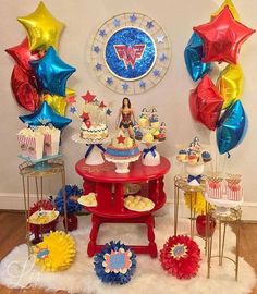 a table topped with cupcakes and cake next to balloons