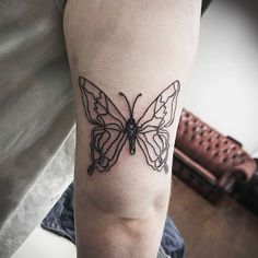 a black and white butterfly tattoo on the arm