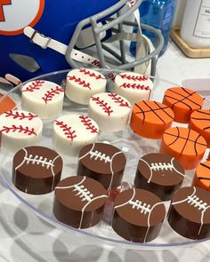 sports themed desserts are displayed on a clear plate with football and basketball cookies in the middle