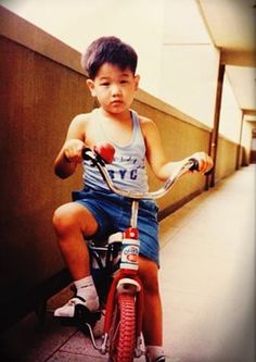 a young boy riding on the back of a bike