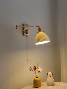 a lamp that is sitting on top of a table next to a vase with flowers