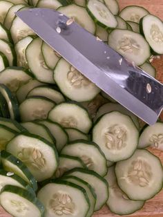 sliced cucumbers and a knife on a cutting board