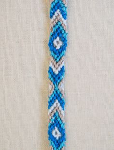 a blue and white beaded bracelet on a mannequin