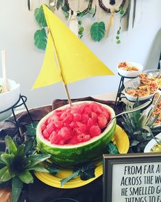 a watermelon is displayed on a table with other foods and decorations around it