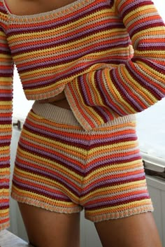 a woman wearing shorts and a striped sweater