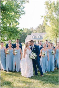 a bride and groom kissing in front of their wedding party