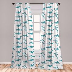 a white curtain with blue birds on it in front of a gray wall and wooden floor