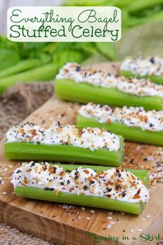 celery on a cutting board with white cream and black pepper sprinkled on top