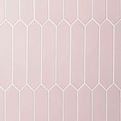 a white tiled wall with hexagonal tiles on the top and bottom half, in various shades of pink