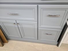 a kitchen with gray cabinets and white counter tops