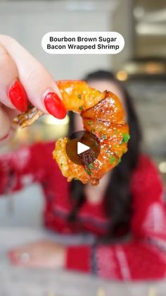 a woman holding up a piece of food in front of her face with the caption bourbon brown sugar bacon wrapped shrimp