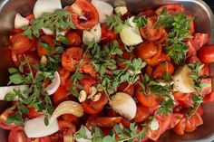 a metal pan filled with lots of tomatoes and onions