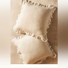 three pillows with ruffled edges on a bed