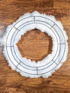 a wreath made out of toilet paper on top of a wooden table